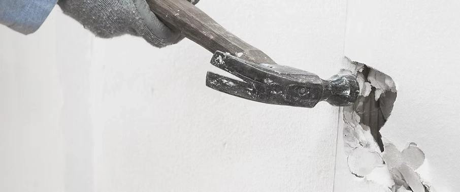 Hammer going into a White drywall